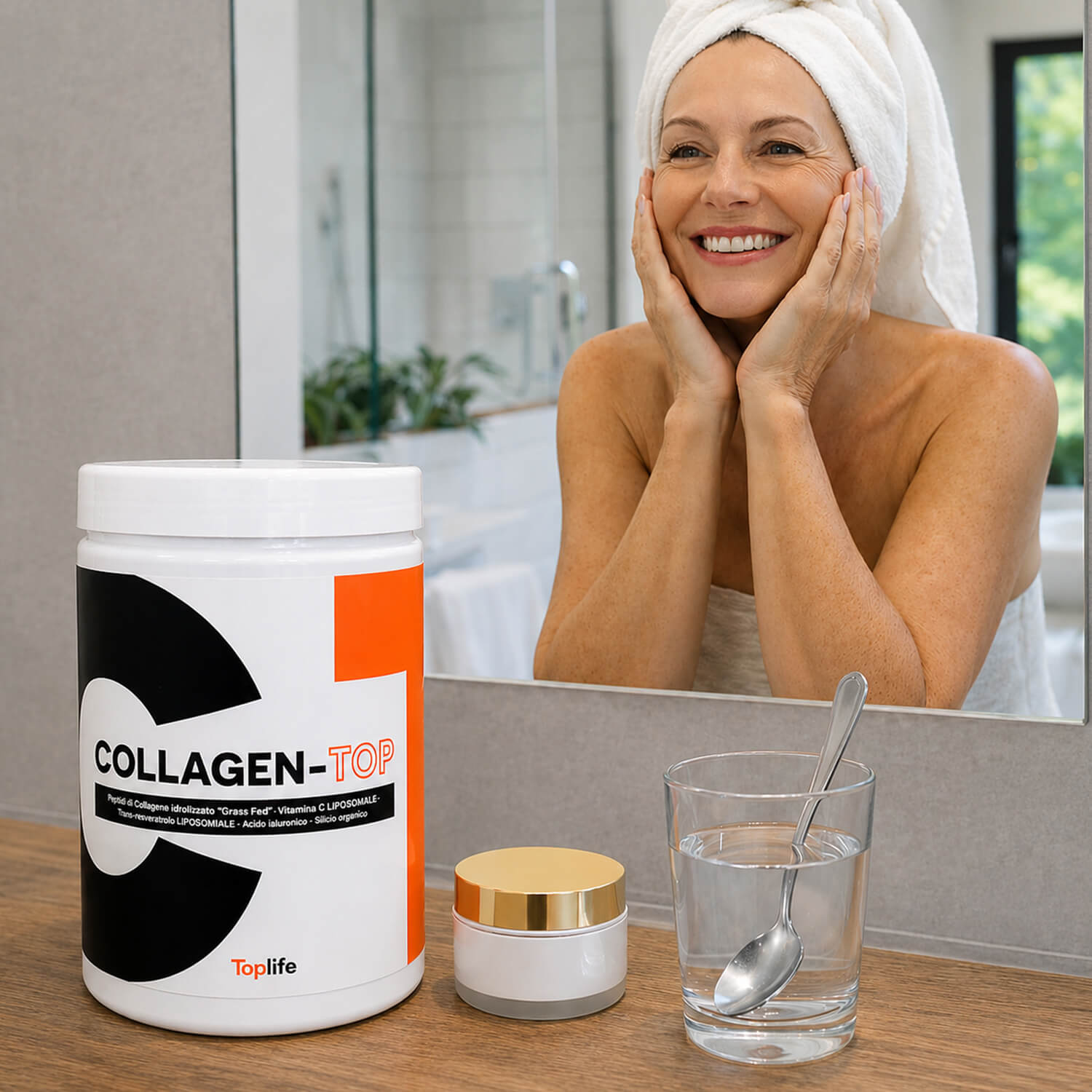Smiling woman with a towel on her head looks into the bathroom mirror beside a large white container labeled COLLAGEN-TOP on the counter.