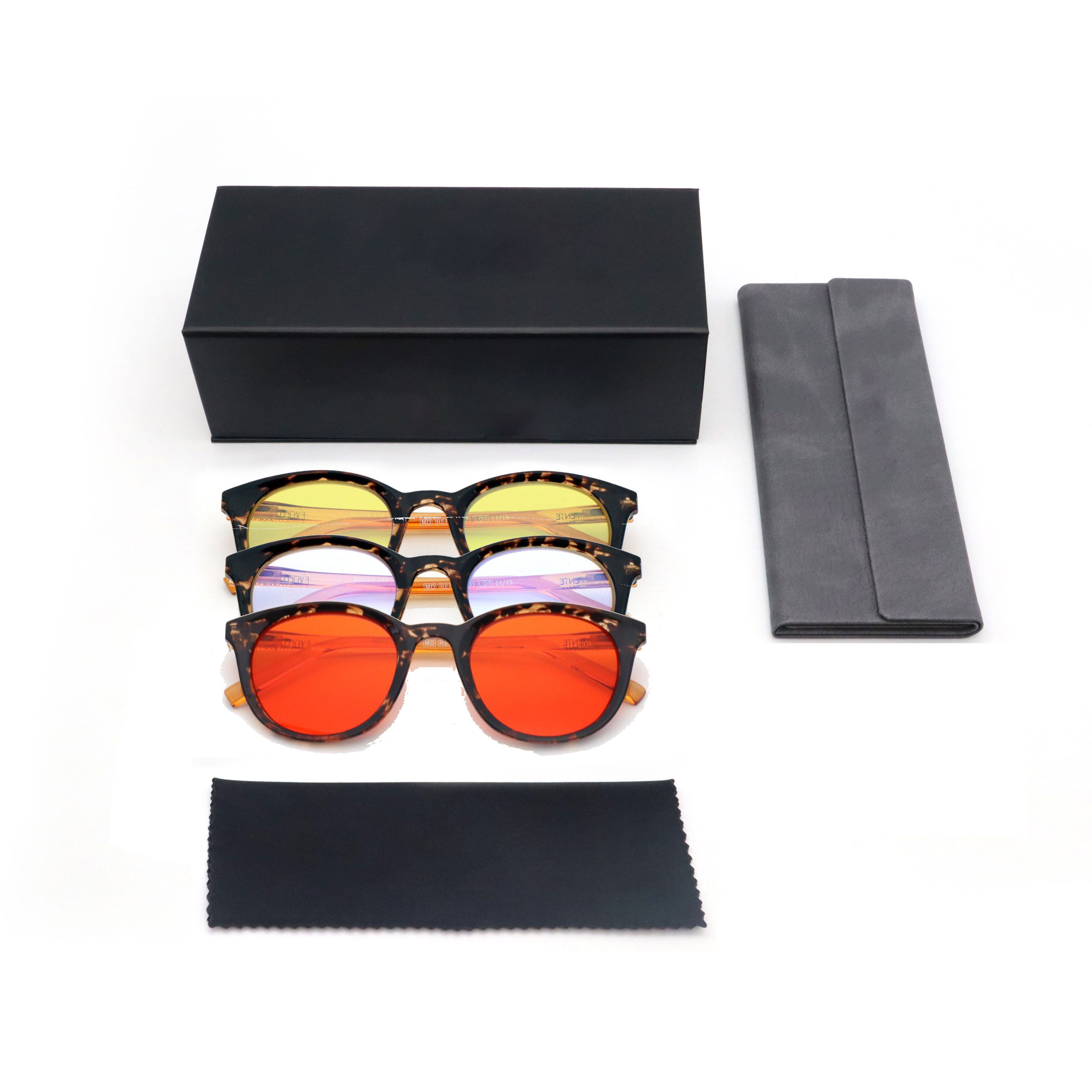 Flat lay of a black box with several tortoiseshell sunglasses and gray cases on a white background.